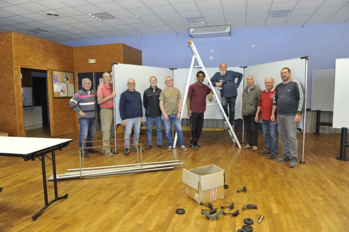 Des membres du club montent les panneaux d'exposition dans la salle